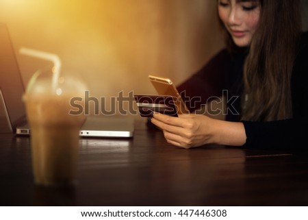 Beautiful woman asian girl using smartphone to find a product shopping online and holding a credit card to pay online shopping cart easy and quickly in holiday deal with low prices promotion concept.