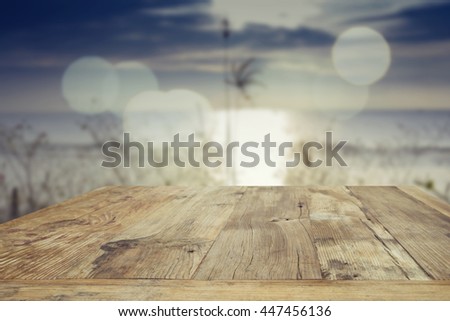 Wood table top on blurred blue sea background - used for display or montage your products. Vintage effect filter style pictures
