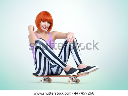 Young redhead girl sitting on a skateboard