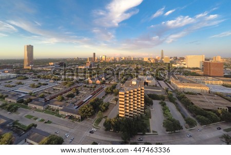 An aerial cityscape view of the Houston Galleria skyline, from the east, as seen from a drone quadcopter flying above Fountain View Dr near Westheimer Road with blue skies and white clouds. 