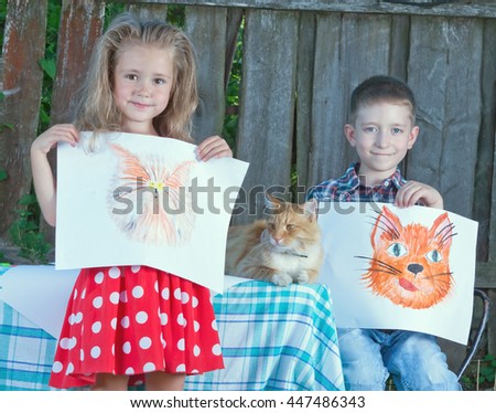 Portrait of happy young children artists, brother and sister who painted his cat. The cat is sitting on the table next.toned