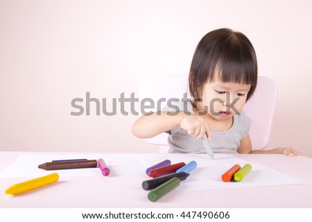 Adorable child drawing with colorful crayons and smiling, with the copy space.