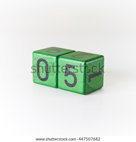 Number five written on a wooden green cube