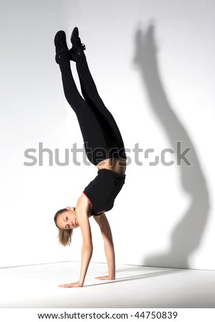 Young girl doing gymnastics over white with a shadow.