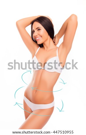 Beautiful  woman smiling and showing her tan slim body with arrows near her belly