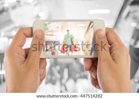 Taking a picture with a smart phone in shopping mall.