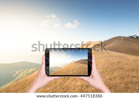 woman hand take a photo with tablet on moutain view