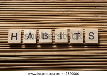 HABITS word written on wood abc block at wooden background.