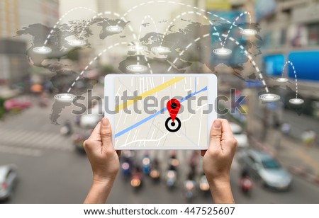 female hands holding a tablet showing part of navigator map on connection line over the world map with blurred photo of traffic jam, Navigation concept,Elements of this image furnished by NASA