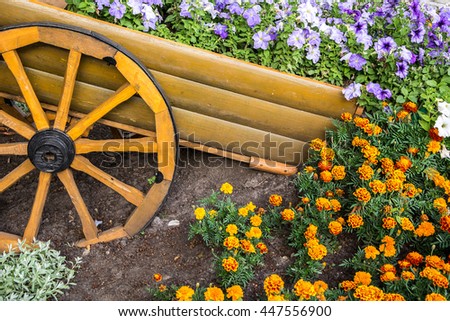 Flowerbed with multicoloured petunias / Scenic View of Colourful Flowerbeds and a Winding Grass Lawn Pathway in an Attractive Formal Garden / multicolored flowerbed on a lawn