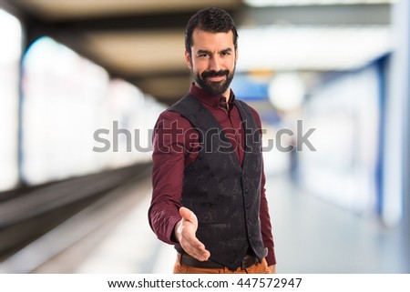 Man wearing waistcoat making a deal on unfocused background