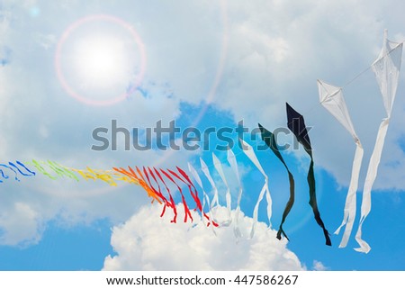 Ribbon is of multi-colored flags against the blue of the cloudy sky or kites
