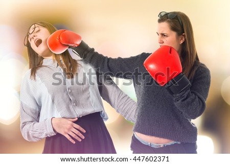 Twin sisters fighting on unfocused background