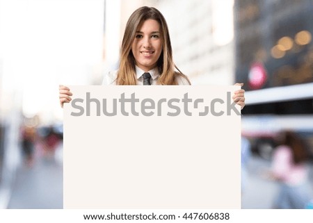 Businesswoman holding placard on unfocused background