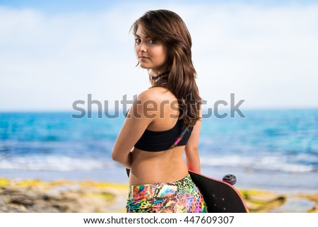 Young girl with skateboard at the beach