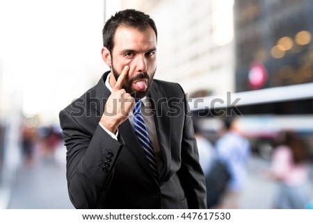 Young businessman making a mockery over unfocused background 