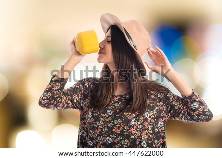 Young woman drinking coffee on unfocused background