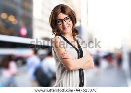Brunette woman with her arms crossed on unfocused background
