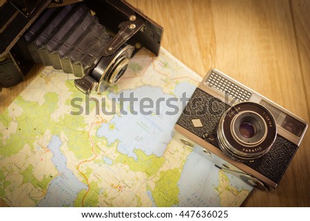 Two, old photo cameras on a paper map. Antique photo
