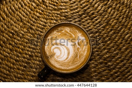 cup of latte art coffee on wooden background