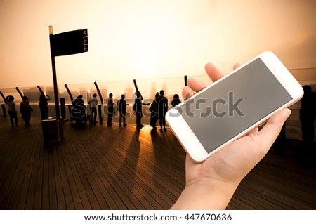 Hand holding smartphone with city people background