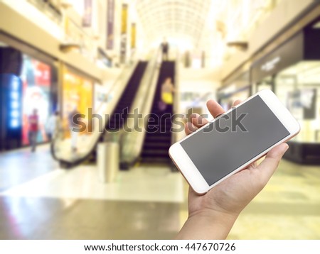 Hand using smartphone in the shopping mall