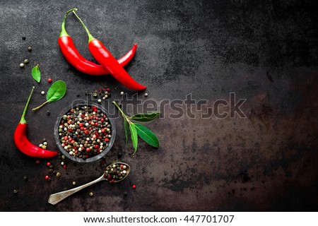 red hot chili pepper corns and pods on dark vintage metal culinary background, top view