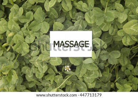 business card on MASSAGE written on green grass background, Top view