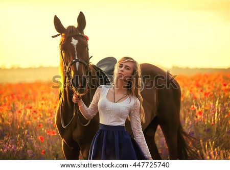 Beautyful blonde woman with horse on a flover field
