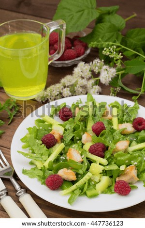 Salad with raspberries, arugula, cucumber, paprika, roasted chicken and sesame. Wooden background. Close-up