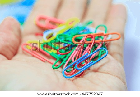 colorful paper clips on hand