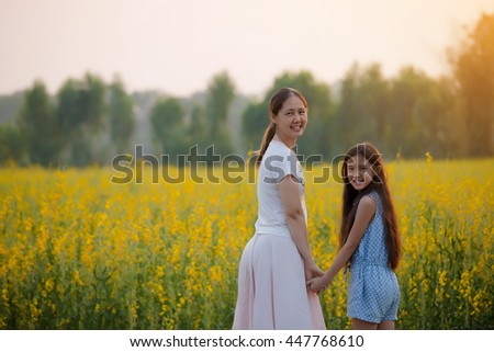 Happy Asian daughter and mother feeling freedom in the flower field, Freedom concept