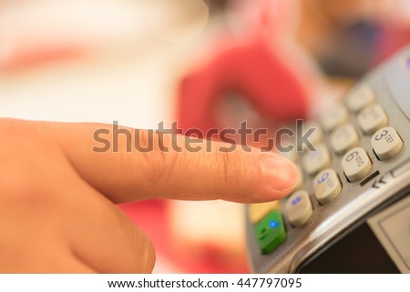 Credit or debit card password payment. Customer hand is entering pin in shop or supermarket. Payment terminal keypad, pin. Buy and sell products and service. Close-up, selective focus.