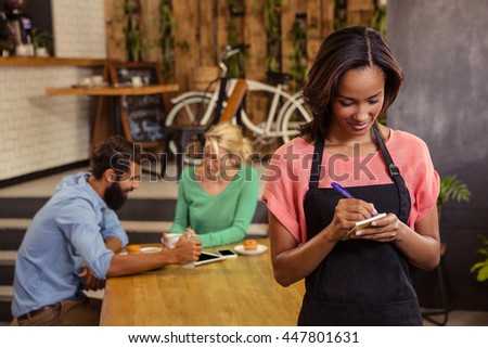 Waitress taking order on a notebook in a cafe