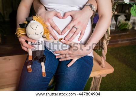 Hands of dad on mum's pregnant belly