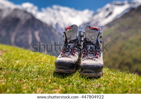 Old hiking shoes and Alpine landscape at background
