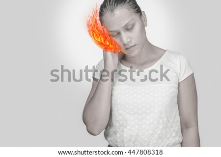 Woman headache.Concept photo with Color Enhanced pale skin with Fire indicating location of the pain.