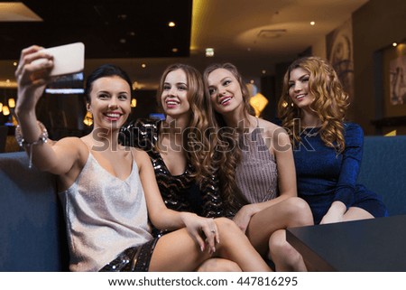 celebration, friends, bachelorette party, technology and holidays concept - happy women with smartphone taking selfie at night club