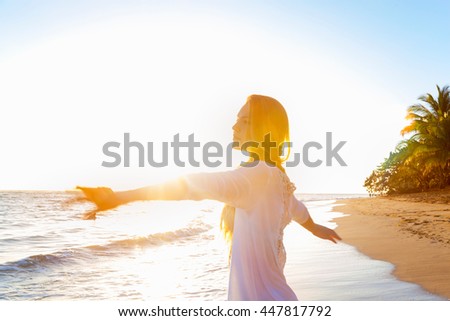Young woman dancing on beach at sunset, Dominican Republic, The Caribbean
