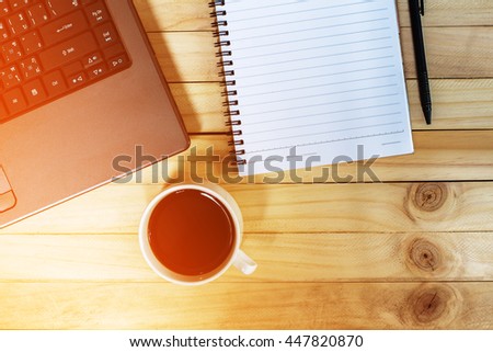 Cup coffee with laptop,blank notebook on old wooden background,vintage tone filter style / copy space