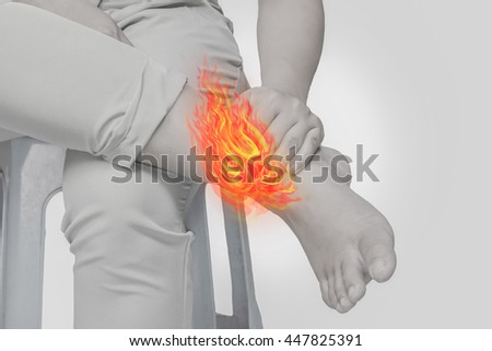 Woman Ankle pain.Concept photo with Color Enhanced pale skin with Fire indicating location of the pain.