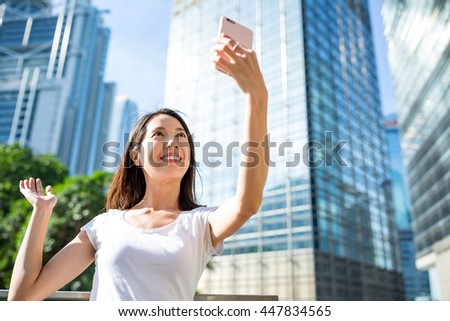 Young woman taking selfie by mobile phone in Hong Kong