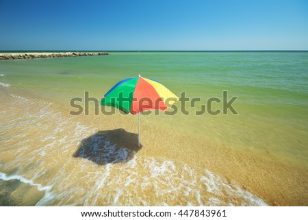 Empty beach. Umbrella on the beach in a sunny day.