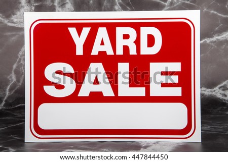 A yard sale sign against a marble background