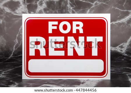 A for rent sign against a mable background