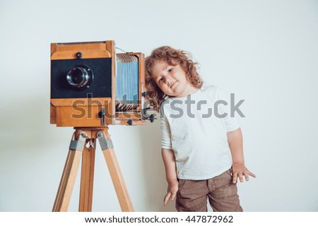 Little boy standing near the camera on a white background