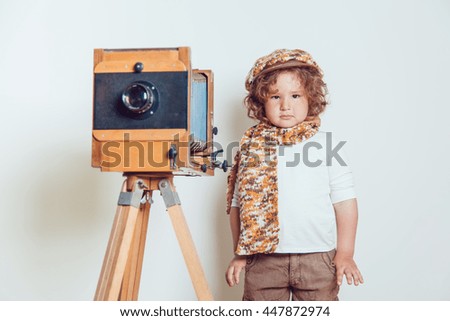 Little boy standing near the camera on a white background