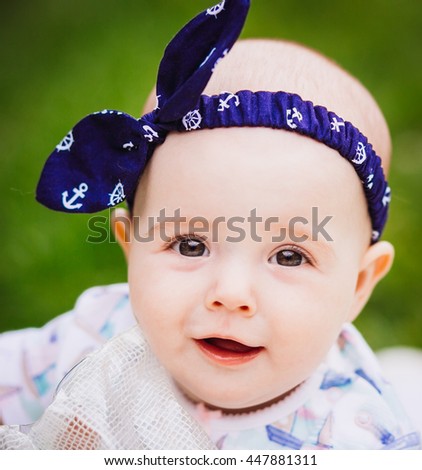 Little smiling girl with a blue bow