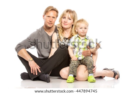 Photo of the happy young family with little child sitting on the floor - isolated on white background.
