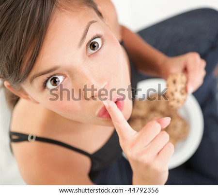 Cookies. Woman eating chocolate chip cookie.  Cute mixed race chinese / caucasian model. Royalty-Free Stock Photo #44792356
